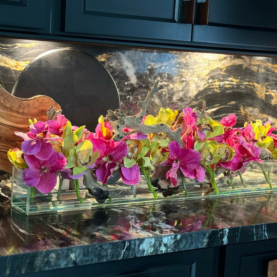 Moderne Haus-Glasvase mit pinkfarbenen Vanda-Orchideen und grünen Cymbidien